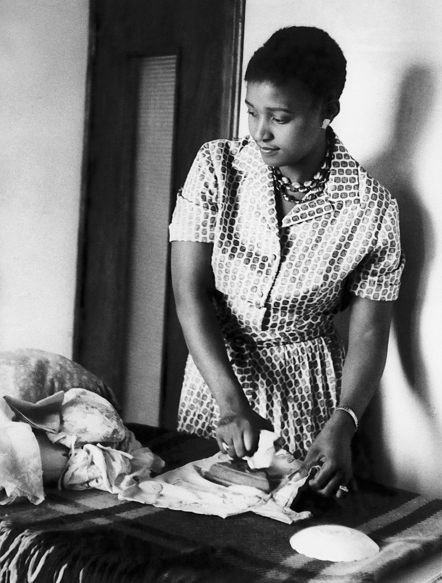 Winnie Mandela at home ironing in 1964, after Nelson Mandela’s imprisonment. © Alf Kumalo Estate