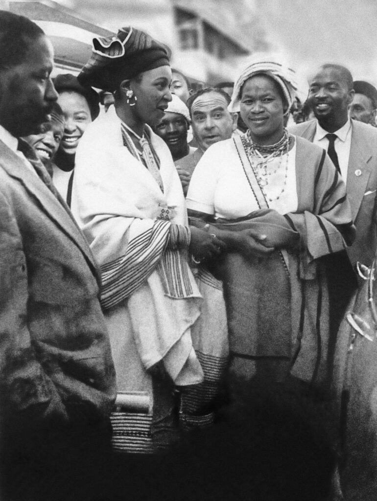 <p>Winnie Mandela and Albertina Sisulu in traditional Xhosa dress outside the Rivonia Trial. <em>© Alf Kumalo Estate</em></p>
