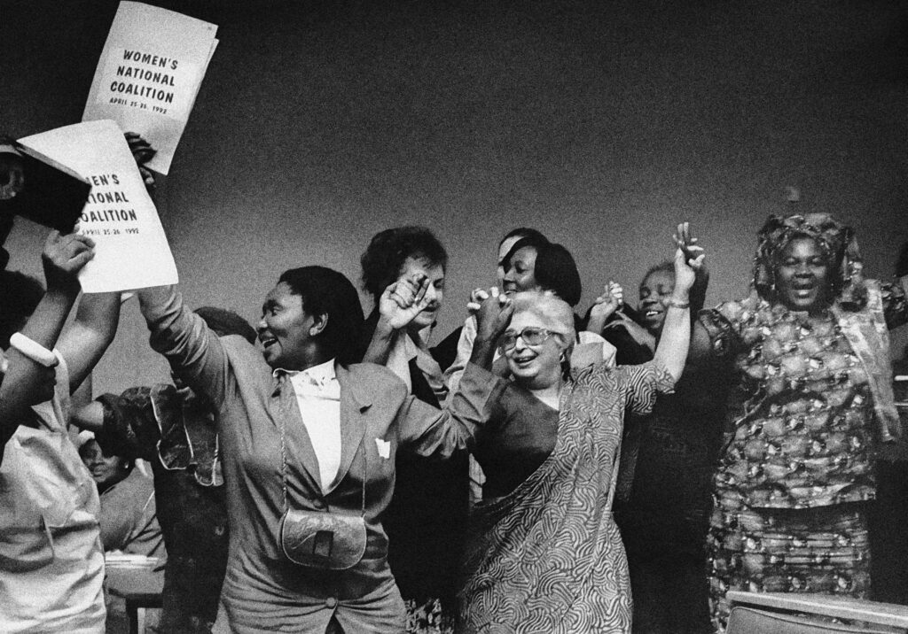 <p>Female liberation struggle leaders celebrate the formation of the National Women’s Coalition in 1991. Frene Ginwala (centre). <em>© Alf Kumalo Estate</em></p>
